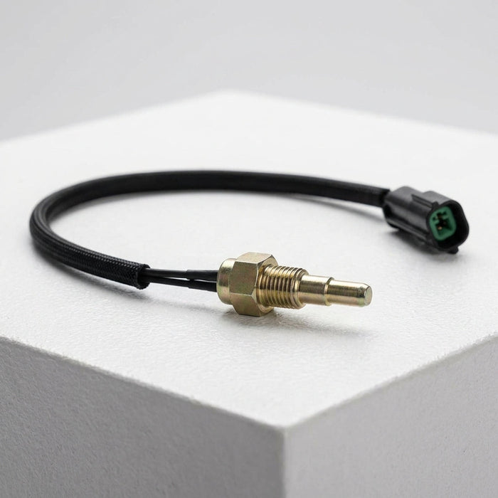 Stylized side view of the compact temperature sensor on a textured white surface, highlighting its slim profile and micro-details.