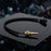 Detailed macro view of the small oil and water temperature sensor with metallic finish, sharp threading, on a black reflective surface.