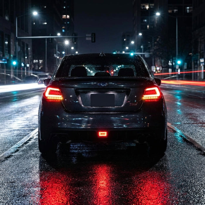 Nighttime street shot of Subaru WRX STI VA with illuminated red sequential LED tail lights and urban reflections, emphasizing modern aggressive styling.